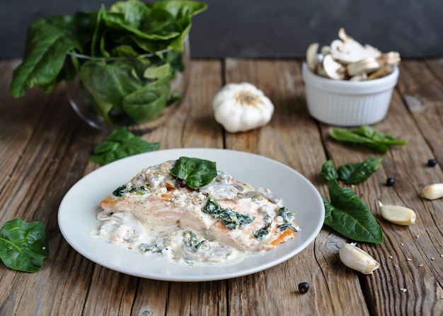 Salmon fillet by Florentine with creamy sauce on the top, mushrooms, garlic and spinach.