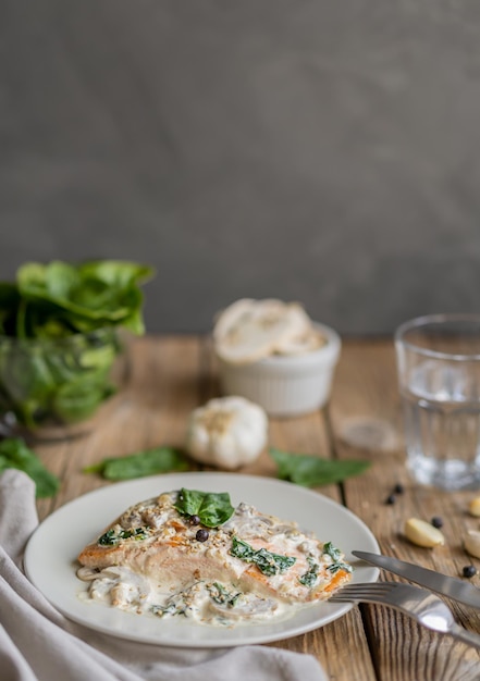 Salmon fillet by Florentine with creamy sauce on the top, mushrooms, garlic and spinach.