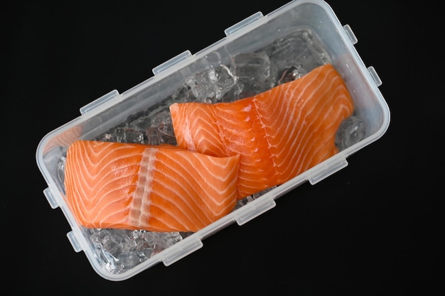 플라스틱 상자에 있는 해산물 연어 생선을 요리하기 위해 얼음에 연어 필레 신선한 생 연어 생선