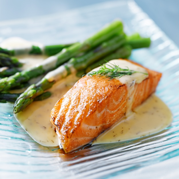 Photo salmon fillet with asparagus and yellow sauce