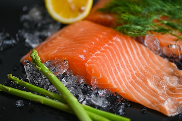 Salmon fillet with lemon asparagus herb and spices fresh raw salmon fish on ice for cooking food seafood salmon fish
