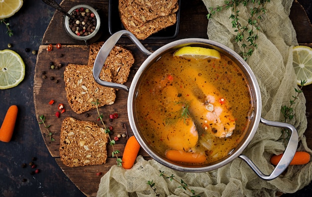 Salmon fish soup with vegetables in pan.