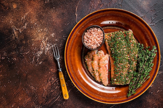 Фото Лосось gravlax, запеченный с укропом и розовой солью на деревенской тарелке