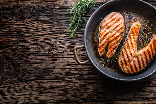 Salmon. Grilled fish salmon. Grilled  salmon steak in roasted pan on rustic wooden table.