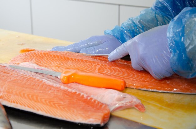 Salmon a man cuts a salmon fish healthy eating red salmon fish photo on fish production