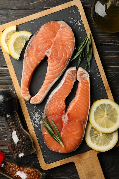 salmon meat and spices on wooden background