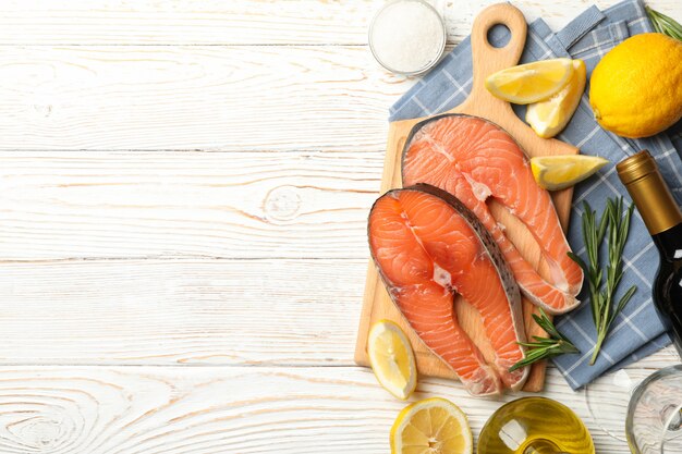 salmon meat and spices on wooden background