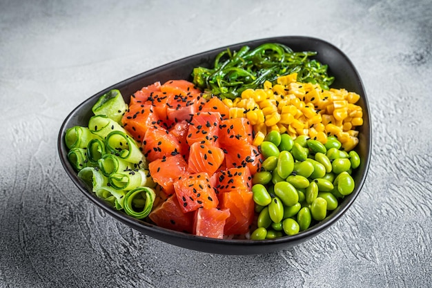 Salmon Poke bowl with Cucumber Edamame and Rice White background Top view