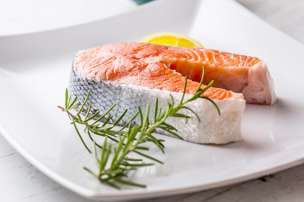 Salmon. Raw salmon steak with rosemary lemon salt and pepper.