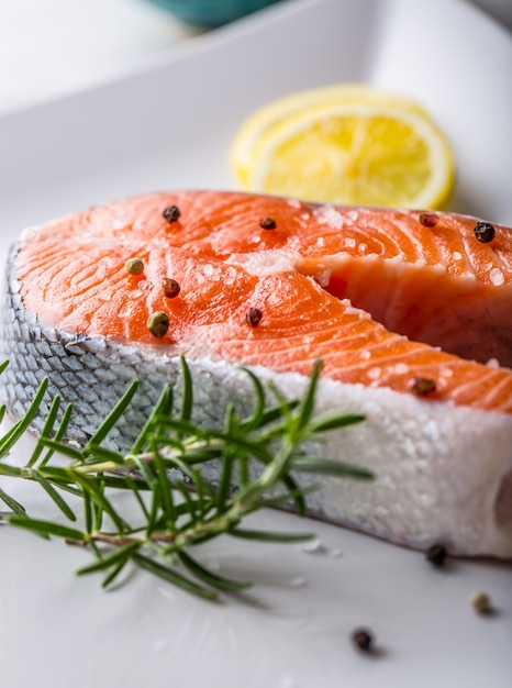 Salmon. Raw salmon steak with rosemary lemon salt and pepper.