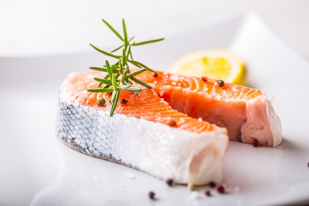 Salmon. Raw salmon steak with rosemary lemon salt and pepper.