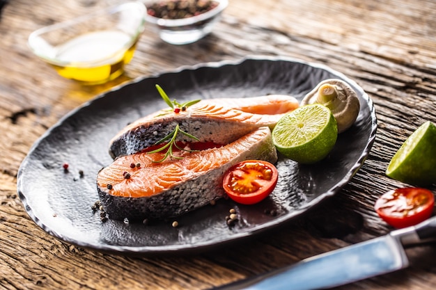 연어 생 스테이크 로즈마리 토마토 버섯 라임 올리브 오일과 향신료 - 클로즈업.