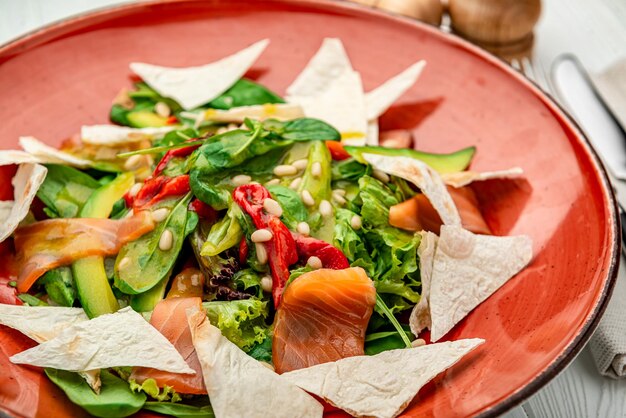 Salmon salad with spinach vegetables and pine nuts