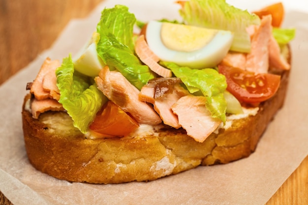 Salmon Sandwich Closeup Salmon eggs lettuce and tomatoes on Bread