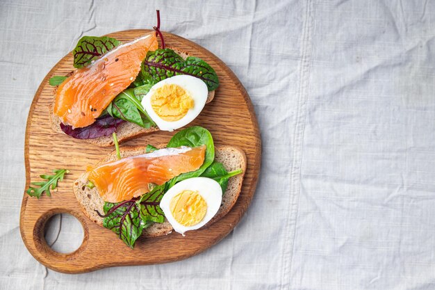 Photo salmon sandwich smorrebrod egg green salad mix cereal bread toast seafood open sandwich fresh