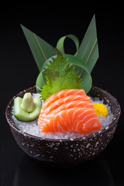 Sashimi di salmone in una ciotola scura