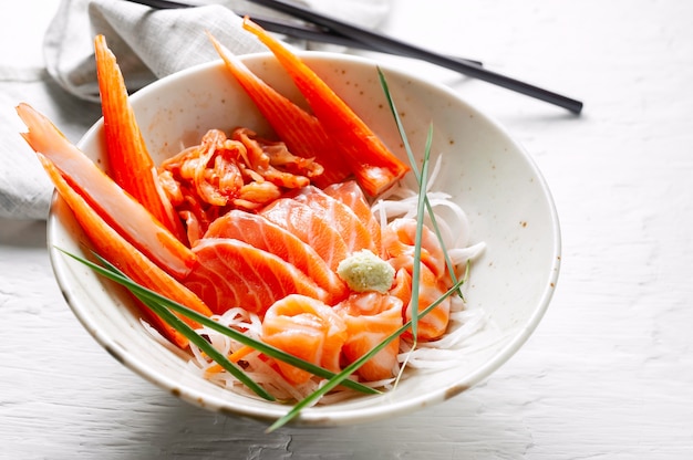 Salmon sashimi and imitation crab stick in Japanese style with kimchi, wasabi