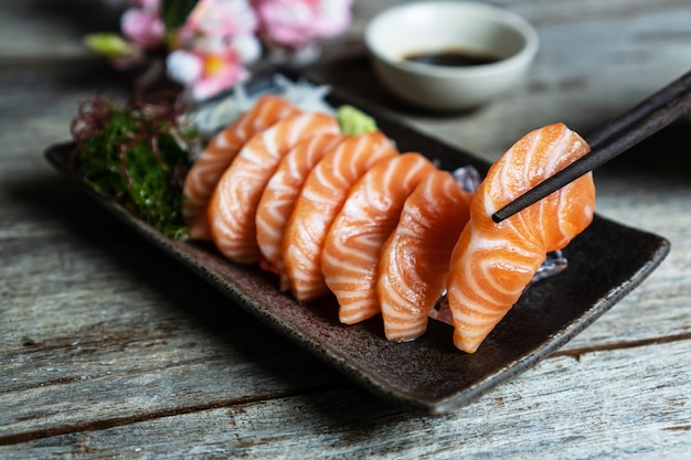 木製のテーブルに醤油とサーモン刺身和食