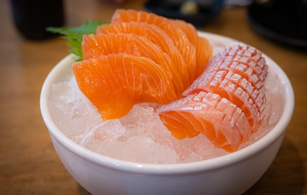 Sashimi di salmone in una tazza di ceramica bianca mantenerlo fresco e fresco con ghiaccio pesce crudo o sashimi