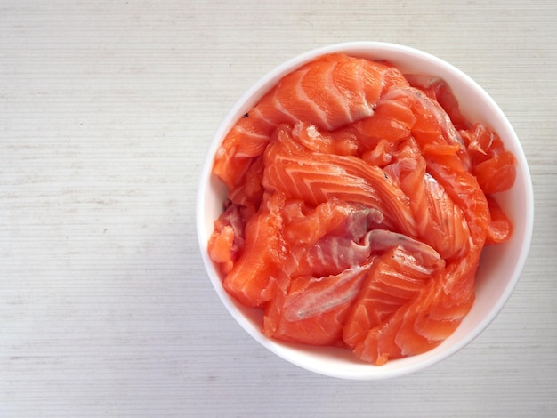 Salmon slices in a bowl isolated on white background