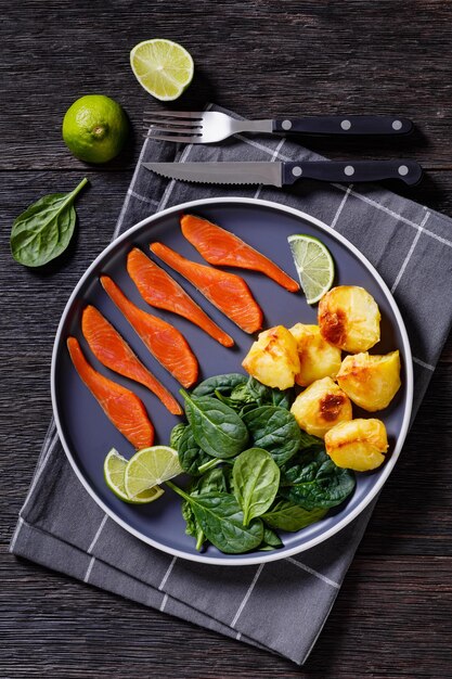 Salmon slices with spinach leaves roast potatoes