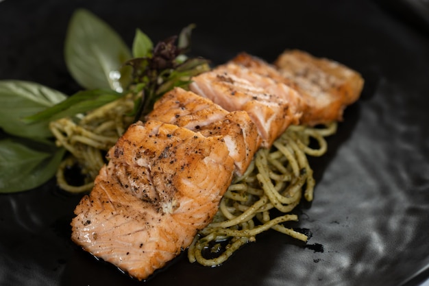 Foto spaghetti di salmone in un piatto nero