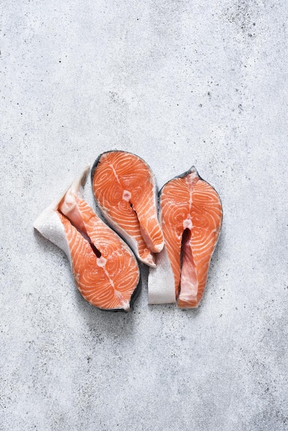 Salmon steak. Raw fresh red fish with spices on a concrete background.