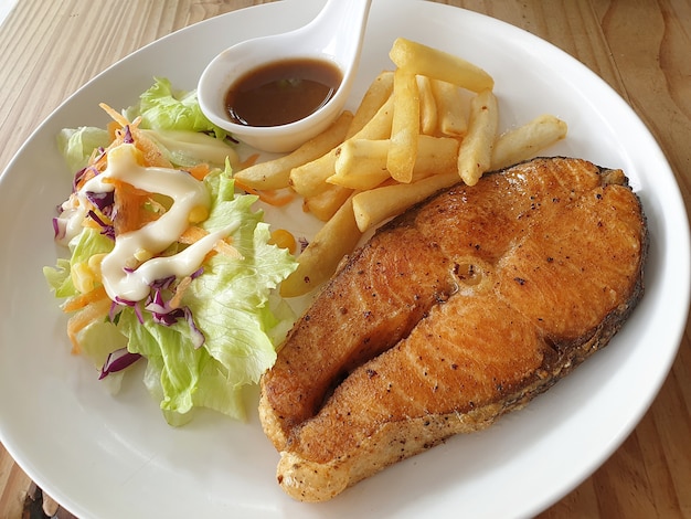 Foto bistecca di salmone insalata patatine fritte