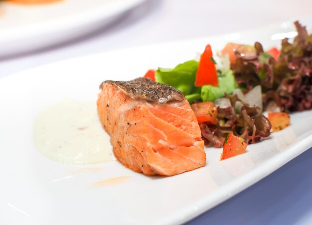 Salmon steak served on white plates. Food image.