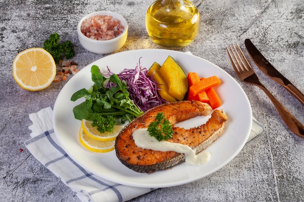 Salmon steak in white plate on table