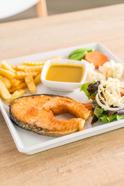 salmon steak with french fries and salad