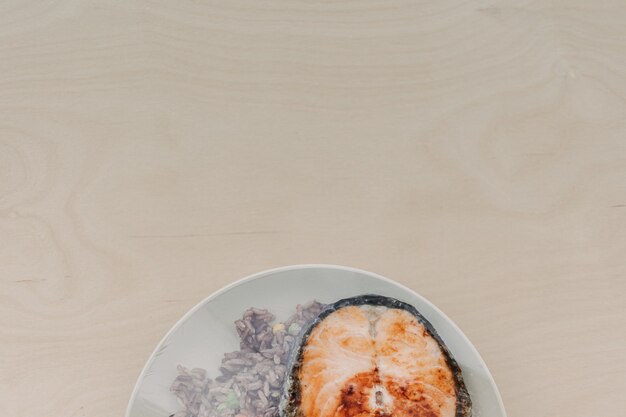 Salmon steak with fried rice on the dish and sealed with plastic