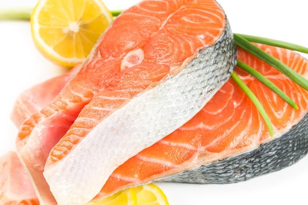 Salmon steak with lemon on white background