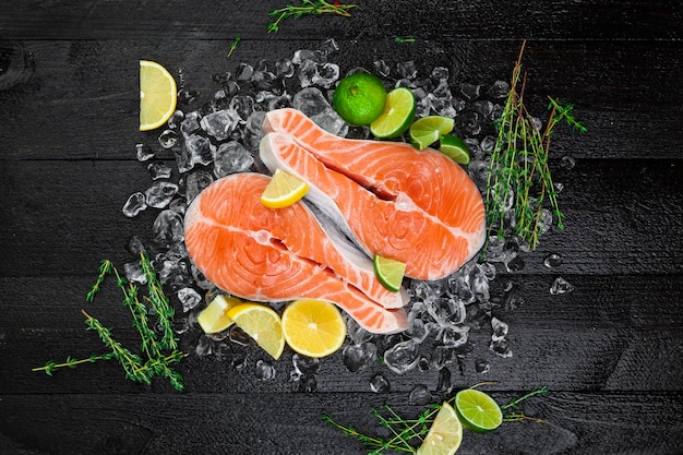 Salmon steaks on black wooden background