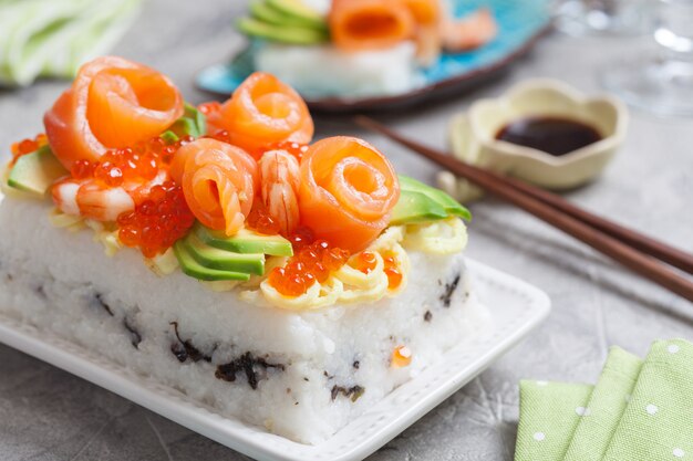 Salmon Sushi Cake with shrimp, red caviar and avocado