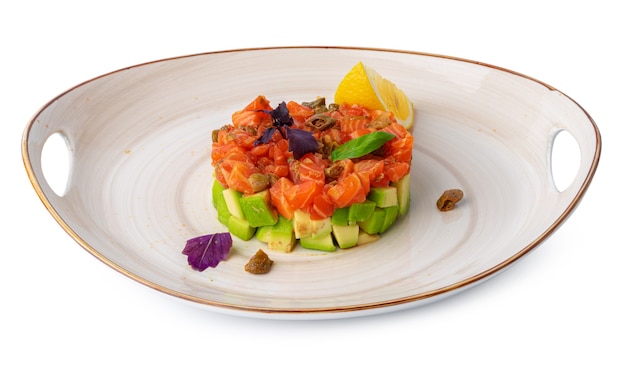 Salmon tartare with avocado on plate isolated on white