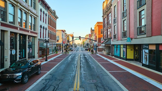 Foto salnut street muncie in bij zonsopgang met gouden dageraad licht op stadsgebouwen boven de weg