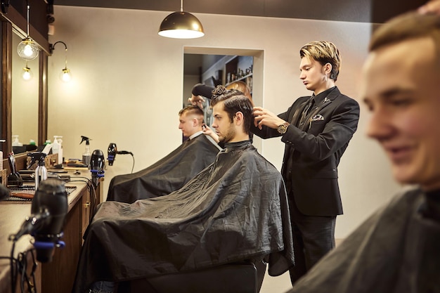 Salon Man in a barber chair The hairdresser serves the client in the barbershop The concept of male cosmetology