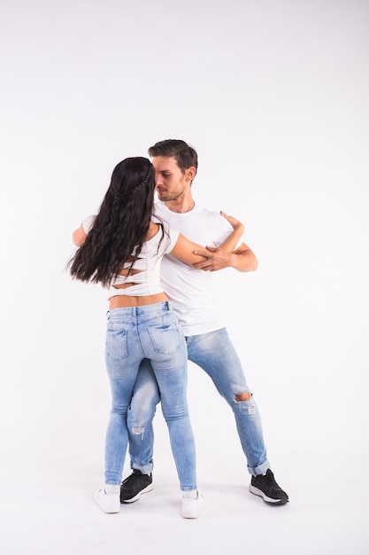 Salsa, kizomba and bachata dancers on white wall. Social dance concept.