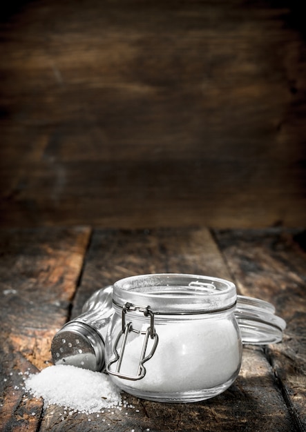 Salt in a glass jar. On wooden table.