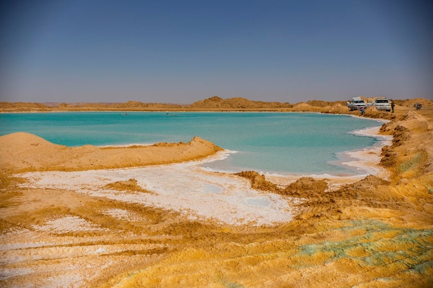 エジプトのシワ オアシス近くの海岸に青緑色の水と白い塩がある塩湖