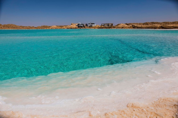 Foto lago salato con acqua turchese e sale bianco sulla riva vicino all'oasi di siwa, in egitto