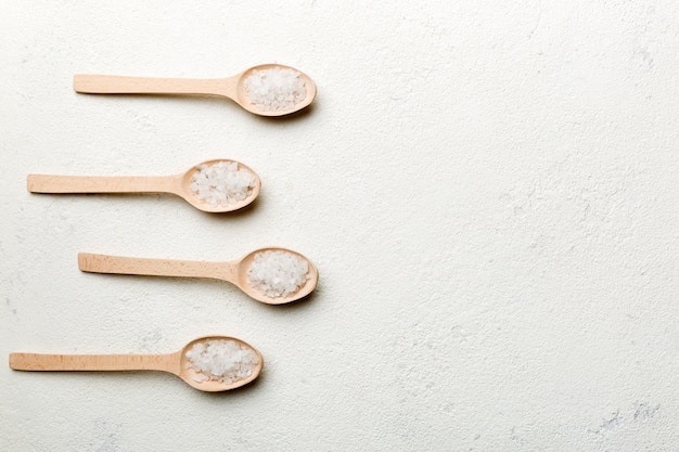 Salt on many wooden spoon on wood background Spoons with different salt