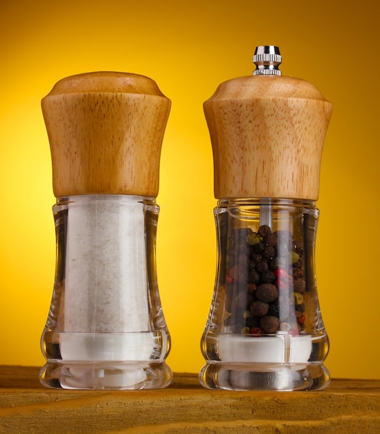 Salt and pepper mills on yellow