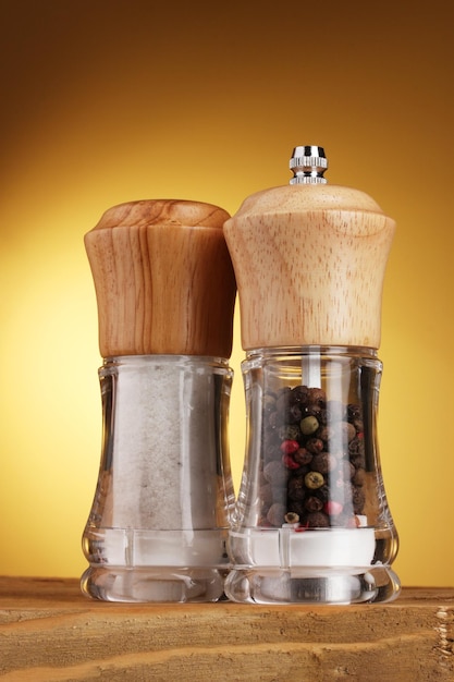 Salt and pepper mills on yellow