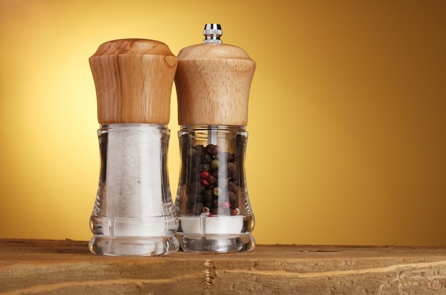 Salt and pepper mills on yellow