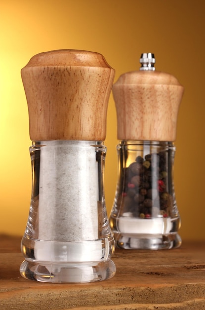 Salt and pepper mills on yellow