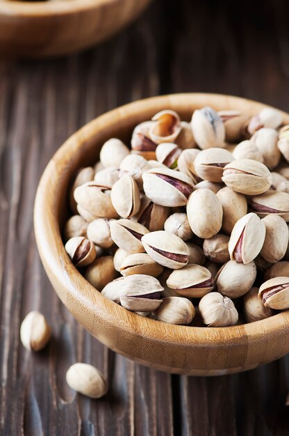 Salt pistachio nuts in the wooden bowl