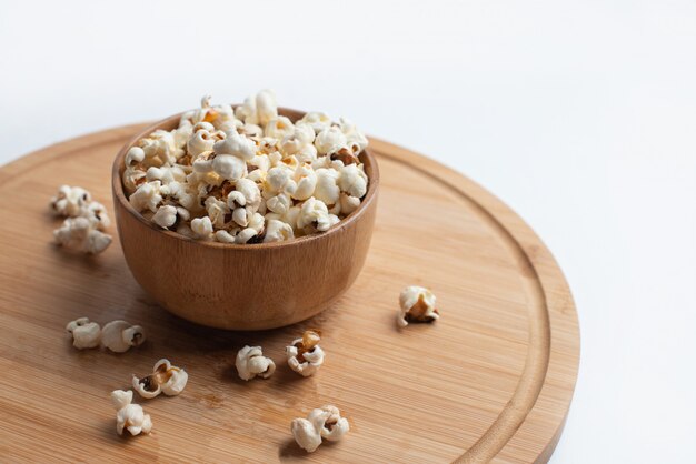 Salt popcorn on the wooden table. Popcorn in a wooden bowl. 