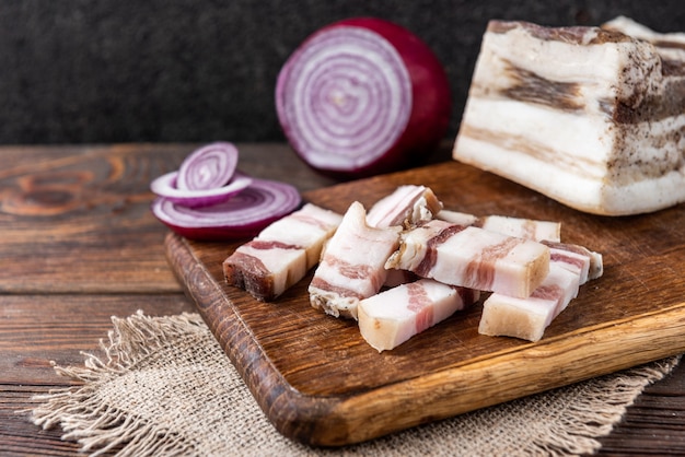 Salt pork fat with onion on wooden board